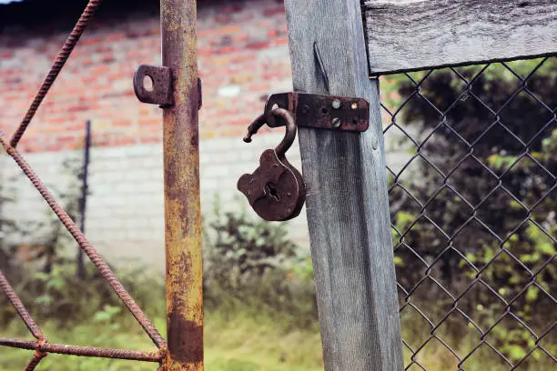 Photo of Rusty padlock open on old gate