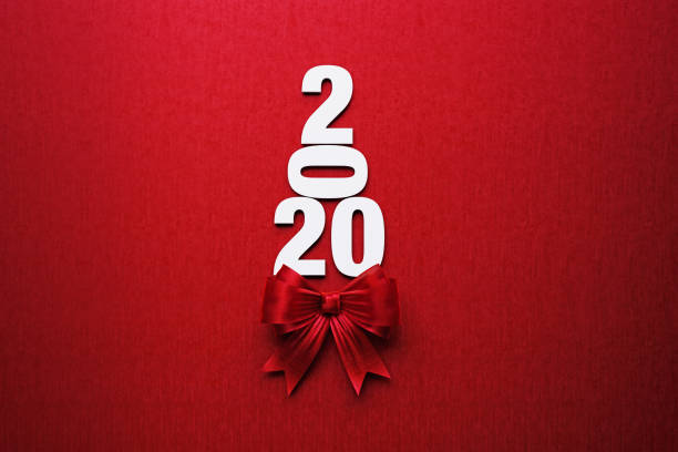 istock 2020 Text Forming A Christmas Tree with Red Bow Tie on Red Background 1161207653
