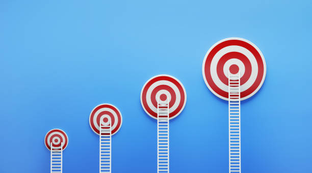 istock White Ladders Leaning on Red Targets on Blue Wall 1161208586