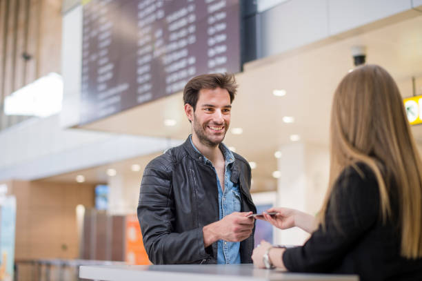 istock Man giving passport to airline check-in attendant 1161211295