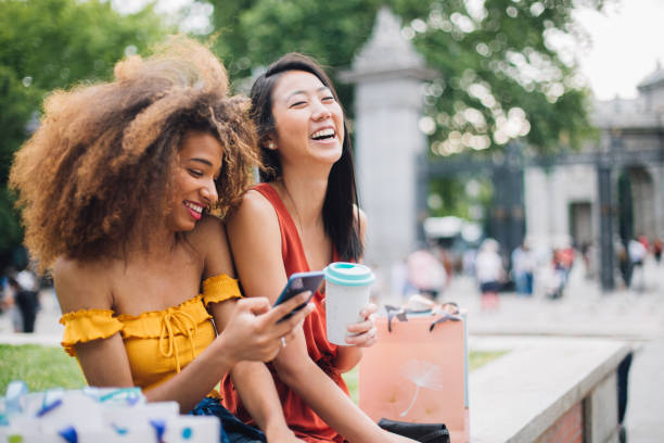 meninas felizes que usam o telefone ao ar livre - spending money adult african ethnicity bag - fotografias e filmes do acervo