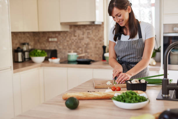 istock Woman chopping leek in kitchen. 1161216785