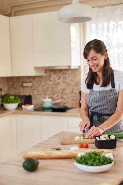 istock Woman chopping leek in kitchen. 1161216876