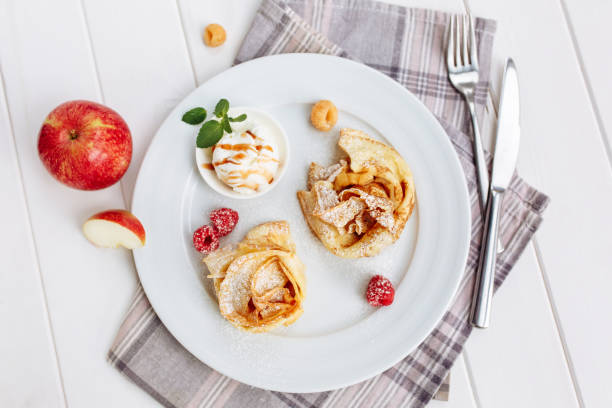 istock Crepes Pancakes with fruit jam and ice cream. Top view on white wooden table 1161216906