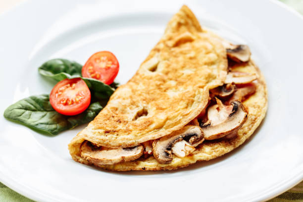 istock Omelet with mushrooms served on white plate with cherry tomatoes and spinach 1161216910
