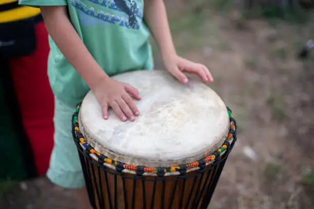 Unrecognizable child playing on djembe.