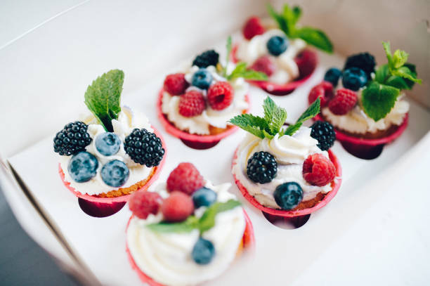 istock Cupcakes decorated with cream, berries and miny in box. 1161218297