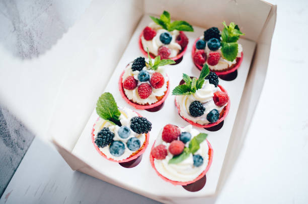 istock Cupcakes decorated with cream, berries and miny in box. 1161218301