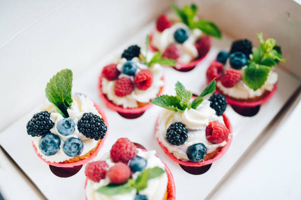 istock Cupcakes decorated with cream, berries and miny in box. 1161218323