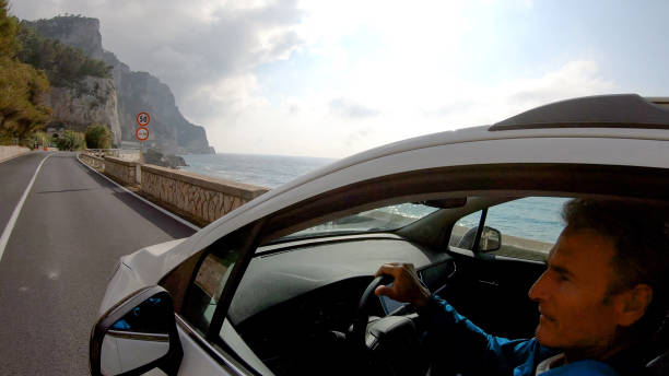 istock Mature man drives car along the seaside 1161219563