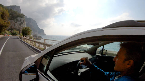istock Mature man drives car along the seaside 1161219577