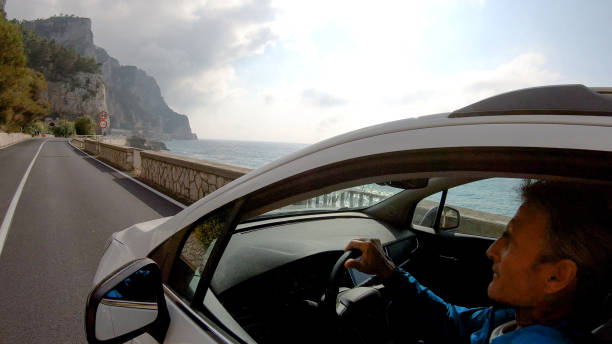 istock Mature man drives car along the seaside 1161219579