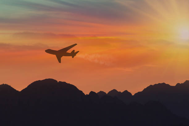 istock Silhouette, Airplane in the sky under mountains at sunset. Copy space 1161222589