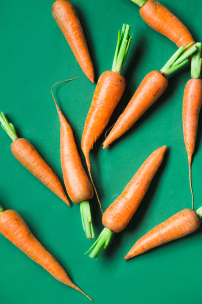 istock A few fresh carrots on green background. 1161222687
