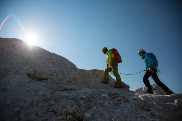 istock Two mountaineers walking on the edge 1161223600