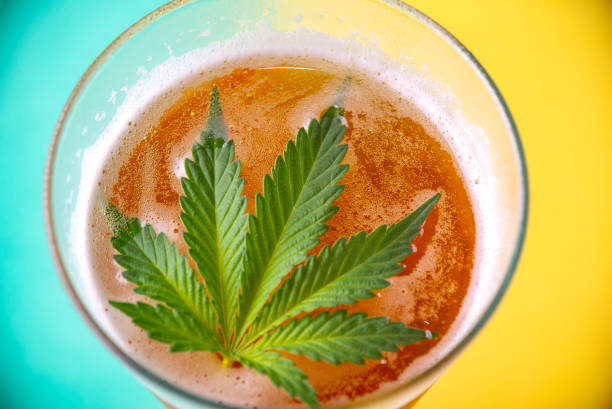 Detail of cold glass of beer with cannabis leaf stock photo