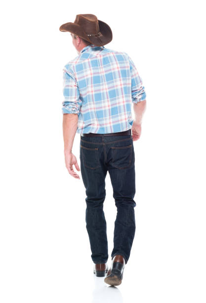 istock Handsome cowboy is walking, rear view 1161225491