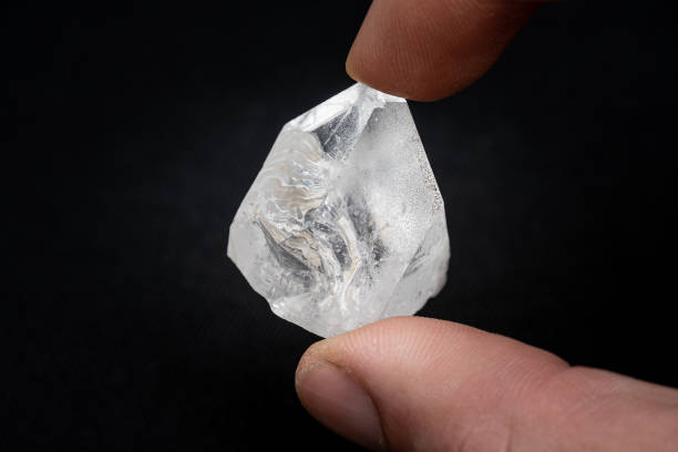 Holding a dob rough diamond formed by volcanic heat and pressure inside the earth stock photo
