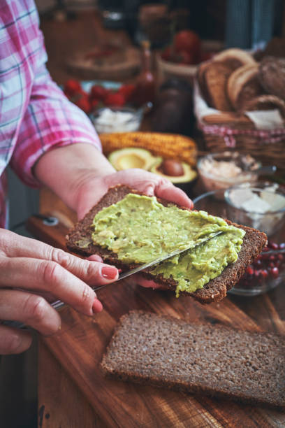 istock Preparing Avocado Sandwich with Brown Bread and Pomegranate 1161226465