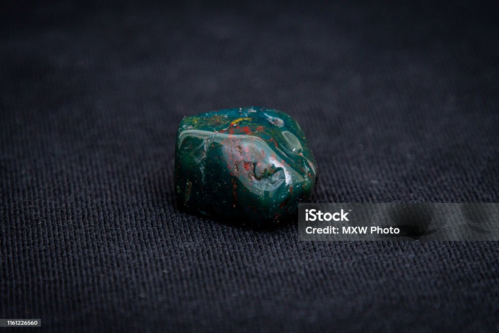 Indian Achat deep green gemstone with red and yellow structures all over it Agate Stock Photo