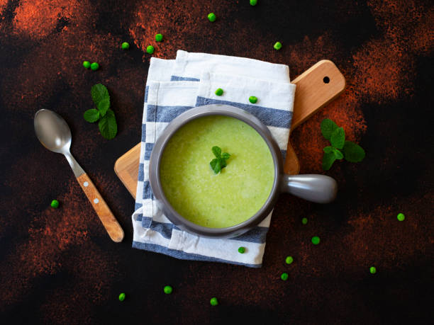 sopa de creme caseiro fresca da dieta das ervilhas verdes e dos bróculos servidos com hortelã. fundo rústico escuro. vista superior - pea and mint soup - fotografias e filmes do acervo