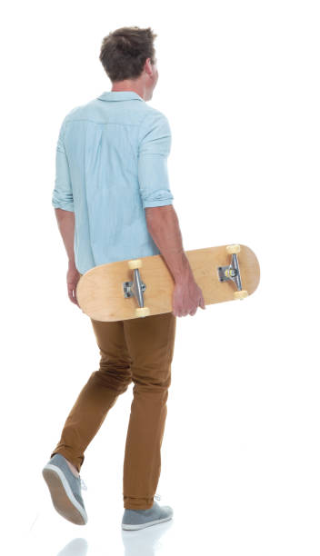 istock Casual well dressed man walking with a skateboard 1161226798