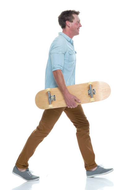 istock Casual well dressed man walking with a skateboard 1161226825