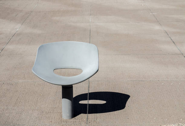 Lone metallic chair sunk in concrete yard