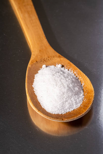 istock Wooden spatula spoon with salt crystals on mirror metal reflected background 1161229370
