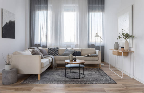 istock Beige comfortable corner sofa with grey pillows in elegant living room interior with white wall 1161230176
