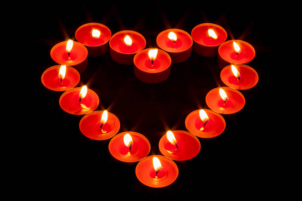 istock A heart made with red candles lit on a totally black background 1161230242