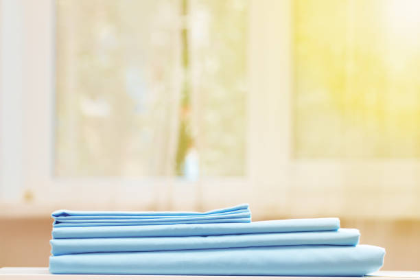 istock Closeup stack of blue clean bedding on the table. Blurred background. Window. 1161232248