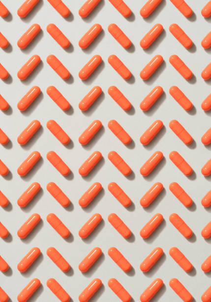 istock Orange pills on gray background 1161240987