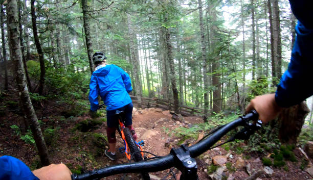 istock View past handlebars to young woman mountain biker riding on rainforest trail 1161241865
