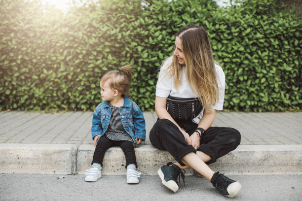 Smiling young mum talking with little daughter
