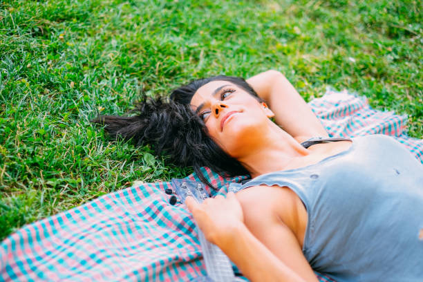 istock Young Woman Lying on the Grass 1161244530
