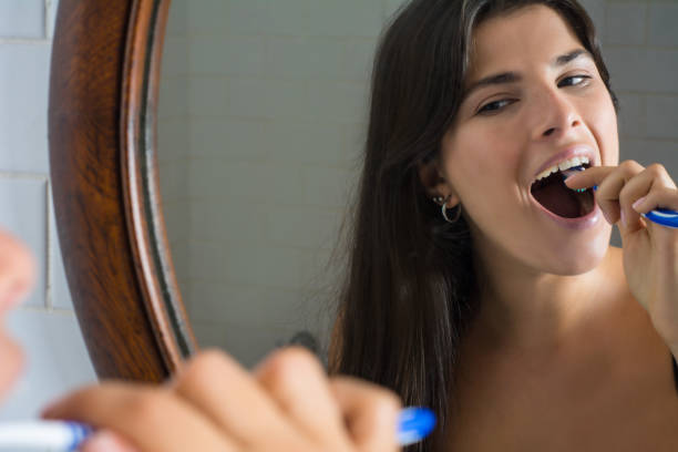 istock young woman with toothbrush brushing teeth 1161246799