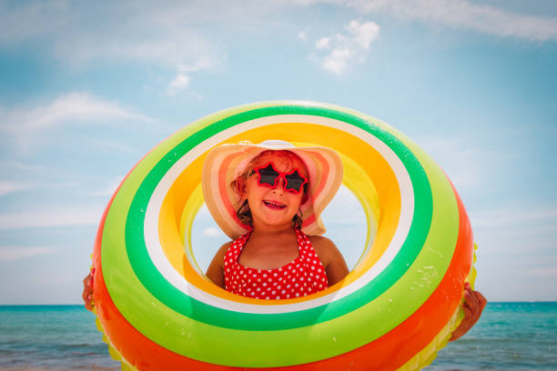 istock happy cute little girl with floating ring at beach 1161249407
