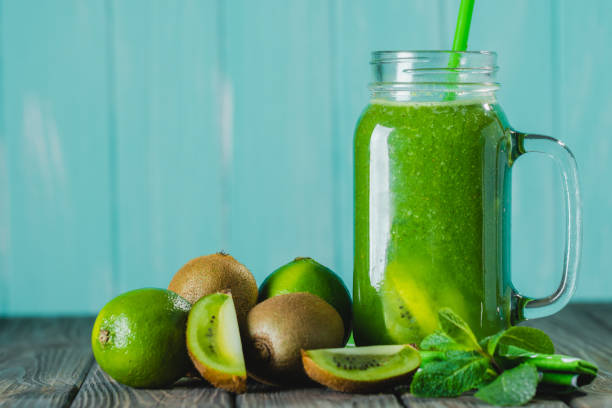 istock Blended green smoothie with ingredients on wooden table selective focus 1161253692