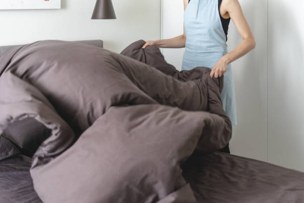 istock Housemaid woman making bed inside bright and light bedroom 1161253884