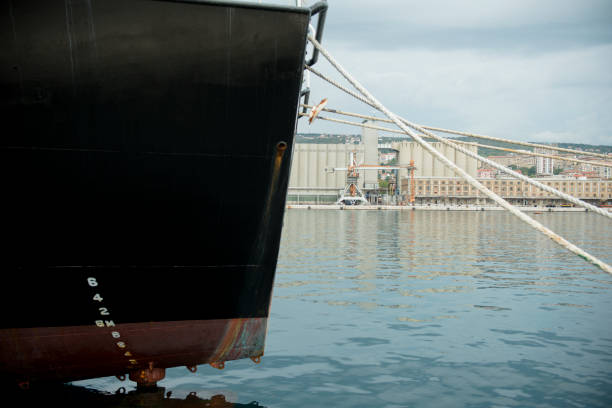istock Big black freighter ship docked in the harbor 1161255014