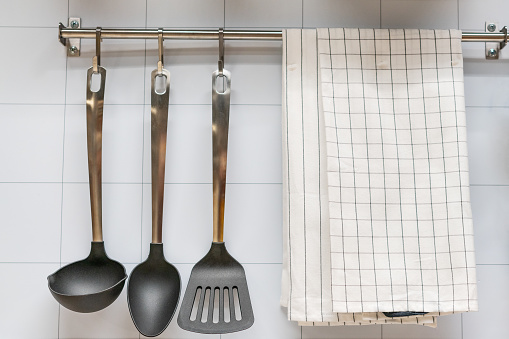 kitchen utensils hanging on the wall and towel