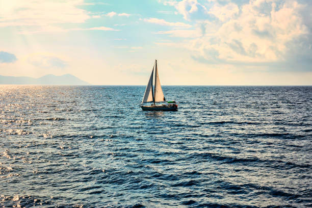Ship yachts with white sails in the open sea. Concept of active holiday