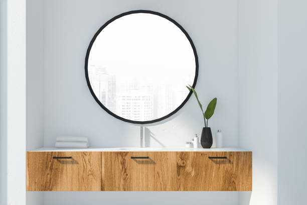 Wooden bathroom sink in white room White bathroom sink standing on wooden countertop with round mirror above it in minimalistic room with white walls. 3d rendering mirror with shelf stock pictures, royalty-free photos & images