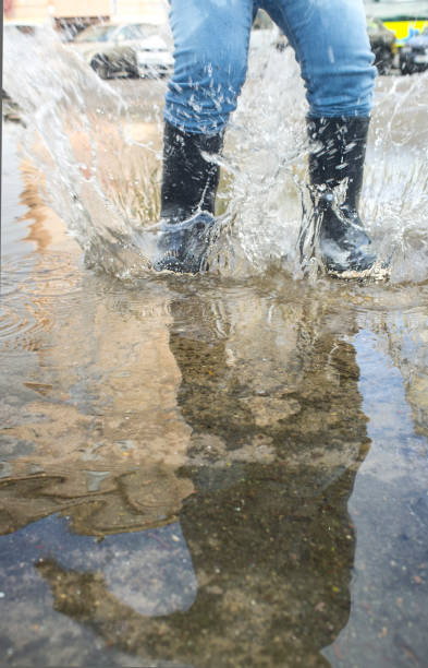 istock 3 years boy having fun at urban puddle 1161262783
