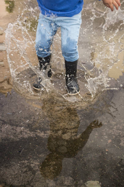 istock 3 years boy having fun at urban puddle 1161262785