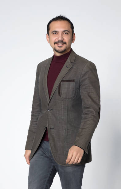 istock Young man wearing brown jacket standing and smiling at the camera on a white isolated background 1161263516