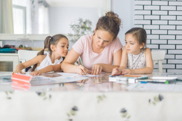 Mother helping daughters with homework Mother helping daughters with homework school supplies photos stock pictures, royalty-free photos & images