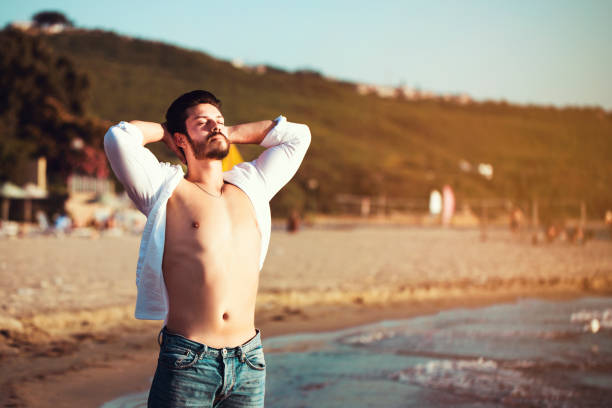 istock young handsome man on the beach in summer season 1161266298