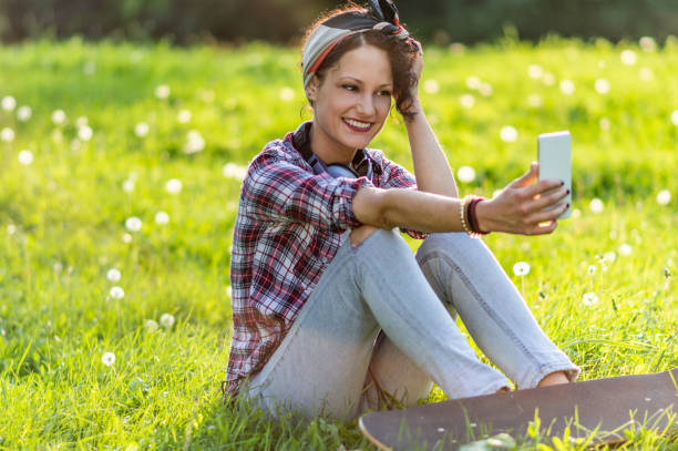 istock Smiling woman taking selfie and holding skateboard 1161267080